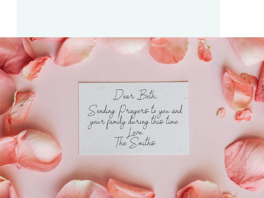A note surrounded by rose petals