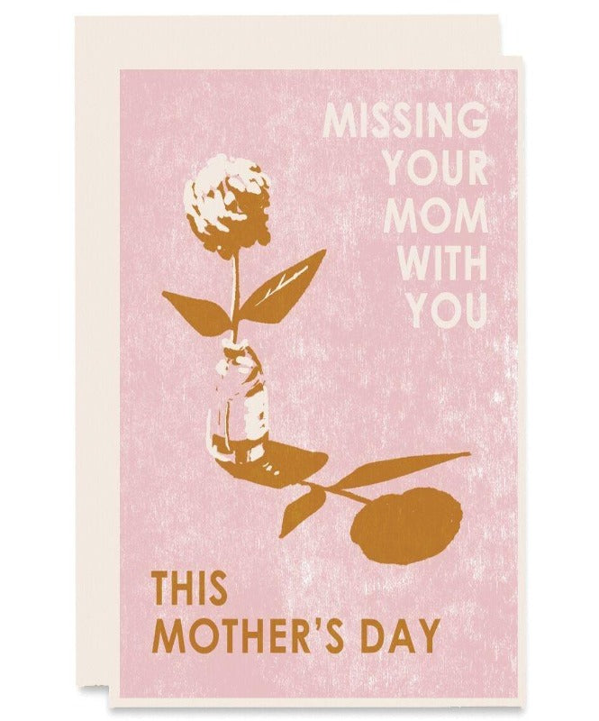 Textured light pink card. With text on the top right that says "missing your mom with you" in white text. On the bottom left "this mother's day" in burnt orange. In the middle of the card is a jar and a flower coming out of the jar. Including the shadow of the flower and jar. The color is burnt orange. 