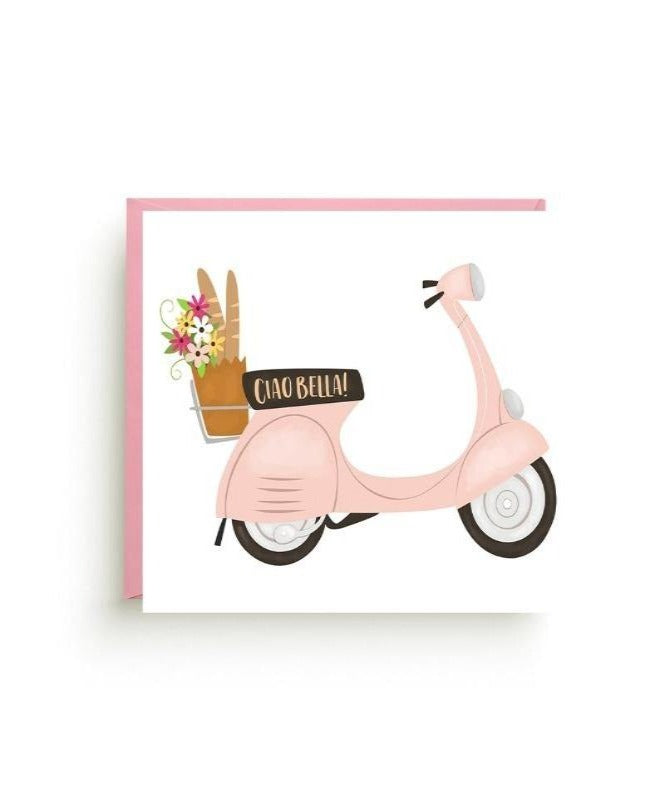 Light pink Vespa with a basket on the back carrying a bouquet of flowers and a baguette.  Text on the seat that reads "ciao bella!"